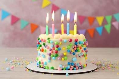 Photo of Cute bento cake with tasty cream and burning candles on white wooden table