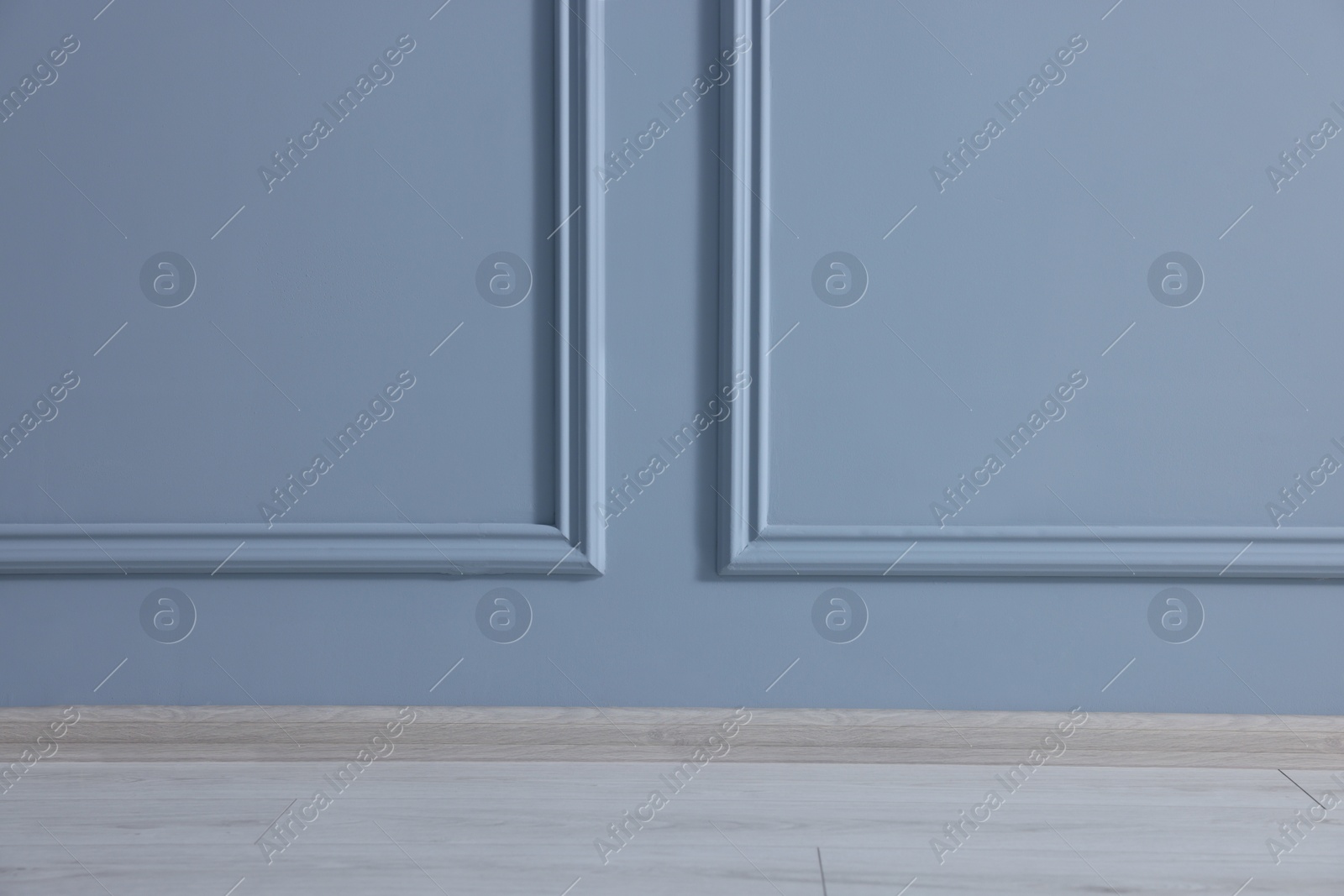 Photo of Beautiful light blue wall with molding in clean empty room