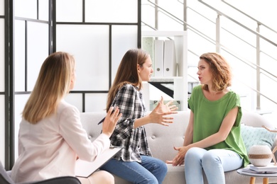 Photo of Young woman and her teenage daughter visiting child psychologist in office