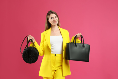 Photo of Beautiful young woman with stylish bags on pink background