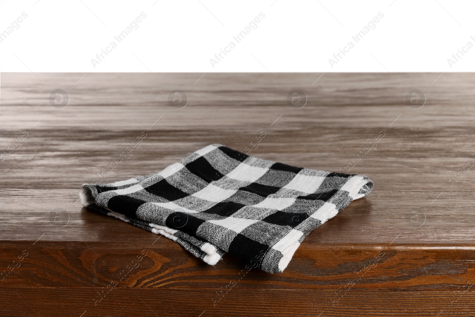 Photo of Checkered tablecloth on wooden table against white background