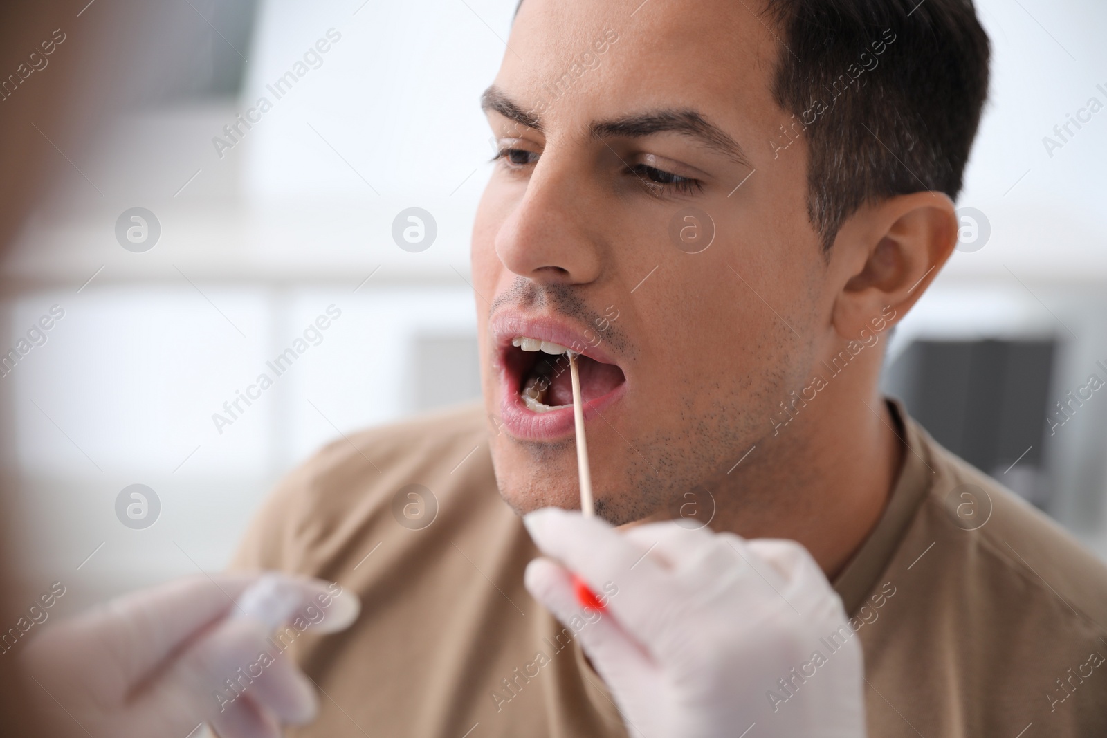 Photo of Doctor taking sample for DNA test from man in clinic