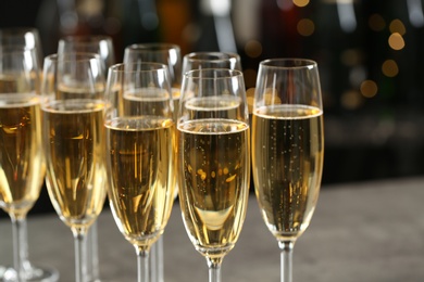 Photo of Many glasses of champagne on blurred background, closeup