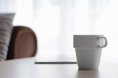 Photo of Ceramic cup on wooden table indoors, space for text. Good morning