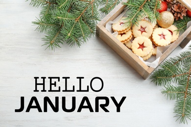 Hello January greeting card. Linzer cookies with sweet jam and fir tree branches on wooden table, flat lay