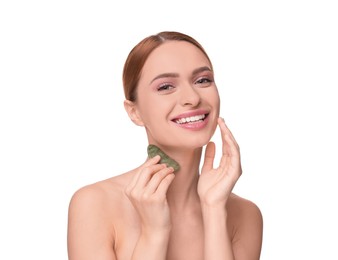 Young woman massaging her face with jade gua sha tool isolated on white