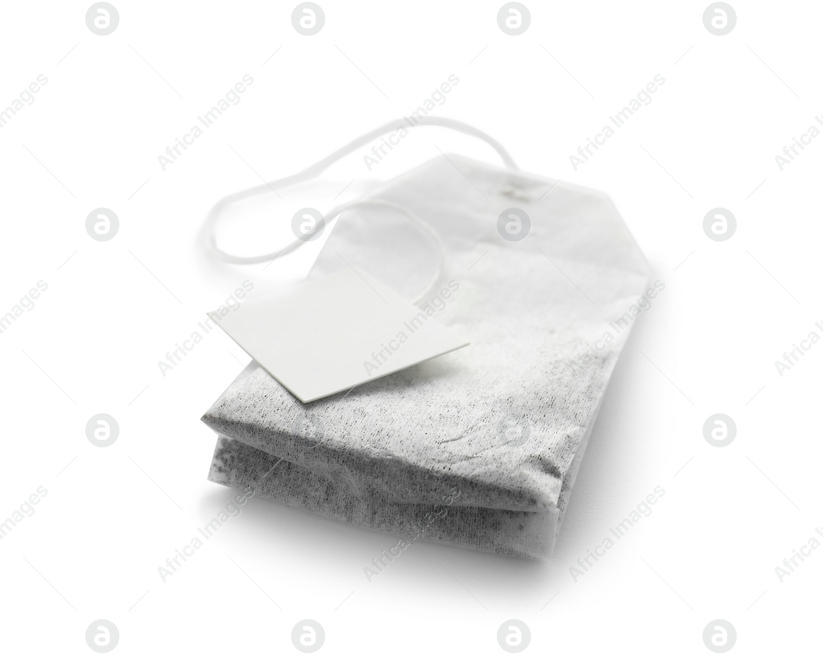 Photo of Unused tea bag with tag on white background