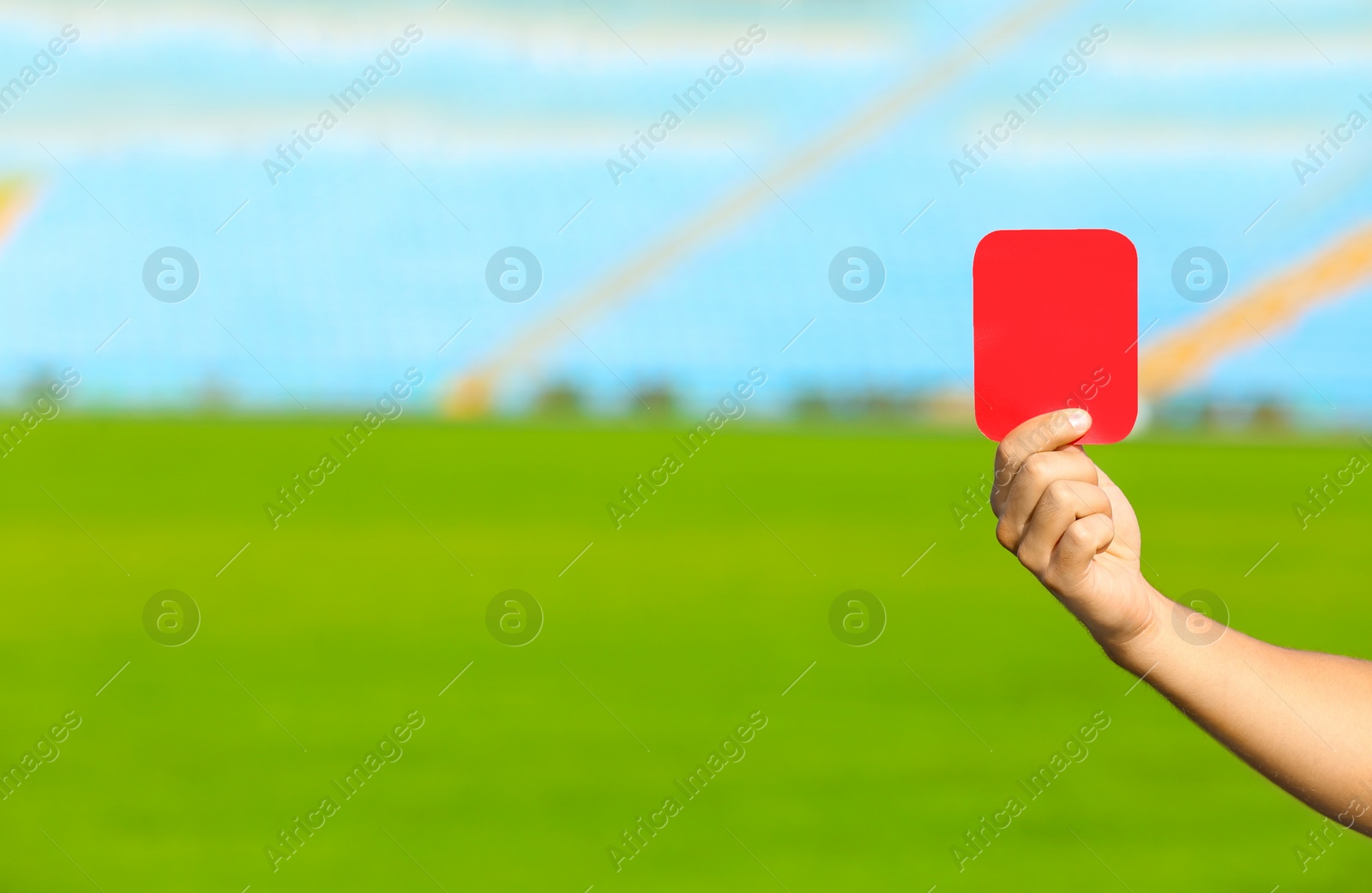 Photo of Football referee showing red card at stadium, closeup with space for text