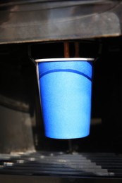 Photo of Vending machine pouring coffee in paper cup, closeup