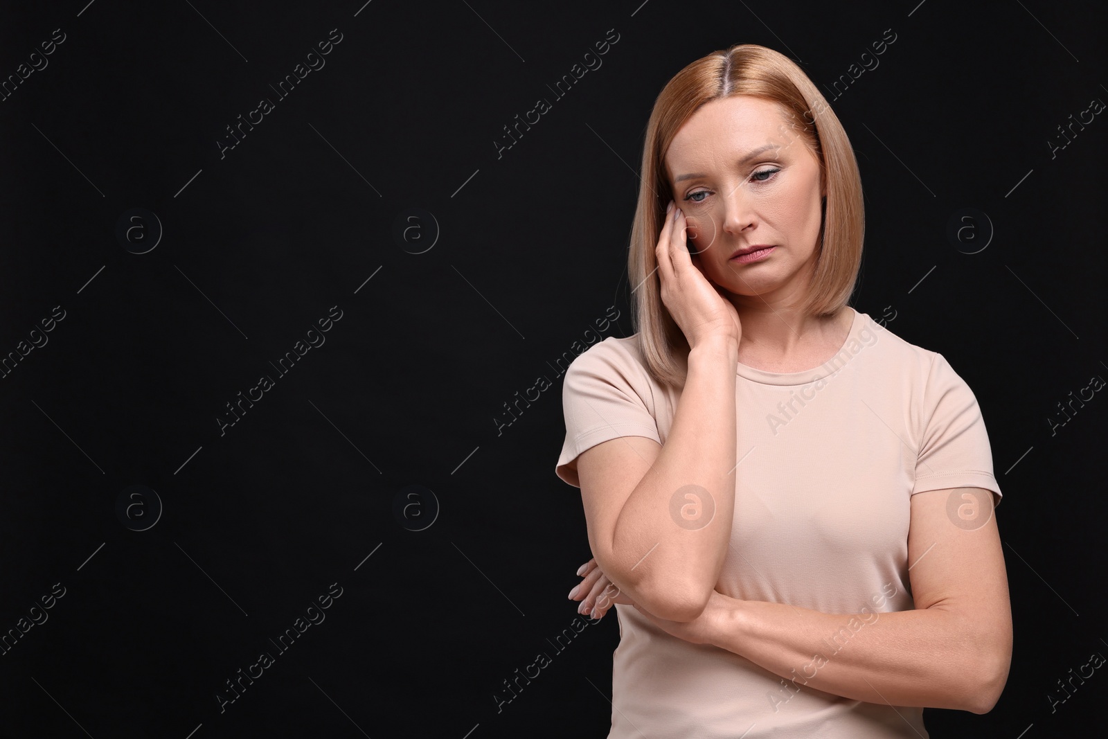 Photo of Portrait of sad woman on black background. Space for text