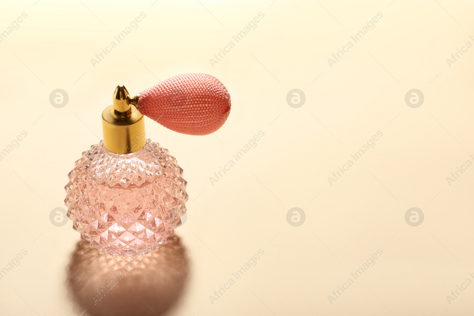 Photo of Elegant vintage bottle of perfume on beige background, space for text