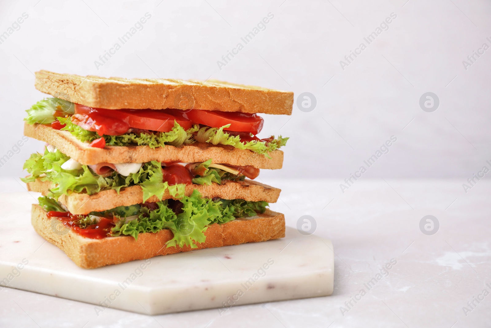 Photo of Yummy sandwich served on light table, space for text