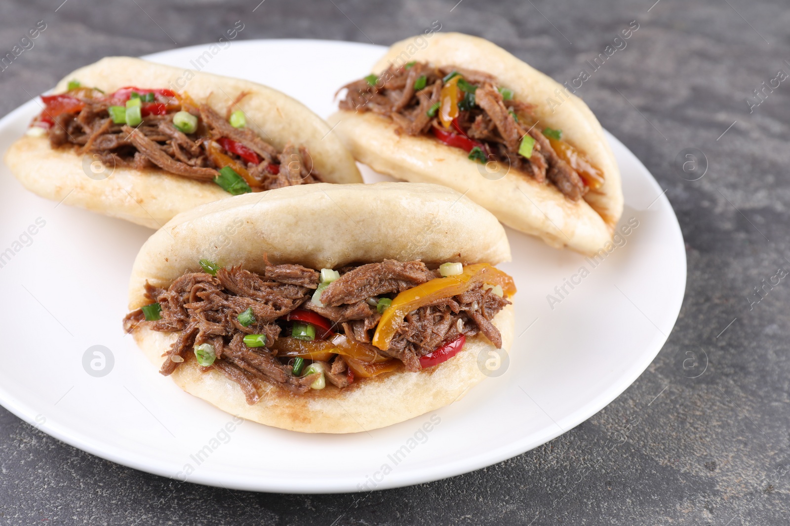 Photo of Delicious gua bao in plate on grey table