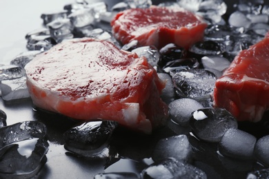 Raw meat and ice cubes on table