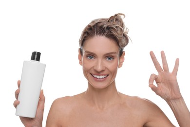 Photo of Washing hair. Portrait of beautiful happy woman with bottle showing ok gesture on white background
