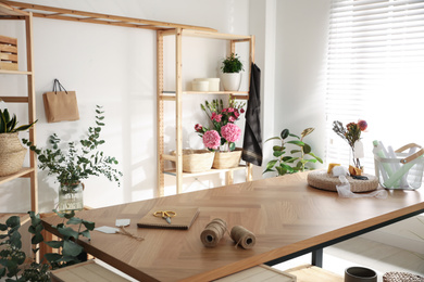 Florist's workplace with fresh flowers and wooden table