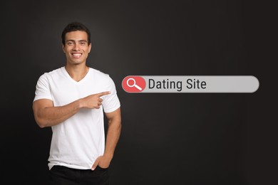 Image of Young African-American man pointing at search bar with request Online Dating on black background