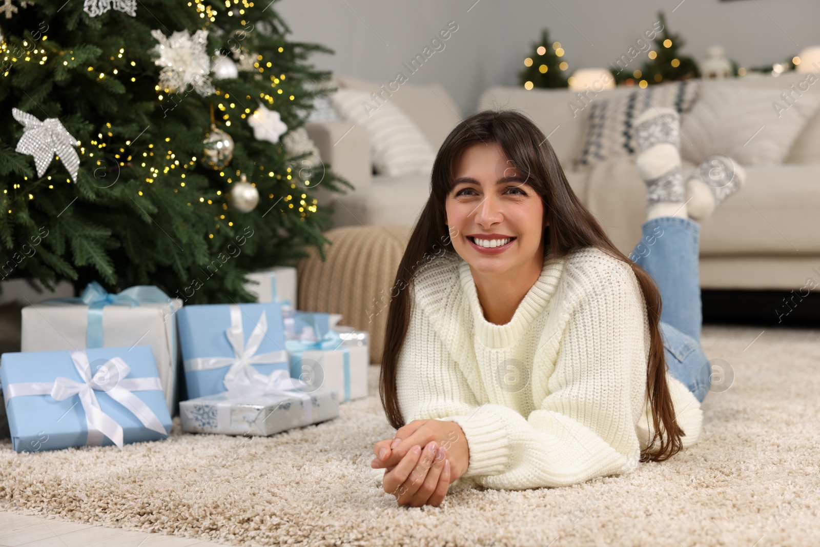 Photo of Portrait of smiling woman with Christmas gifts at home