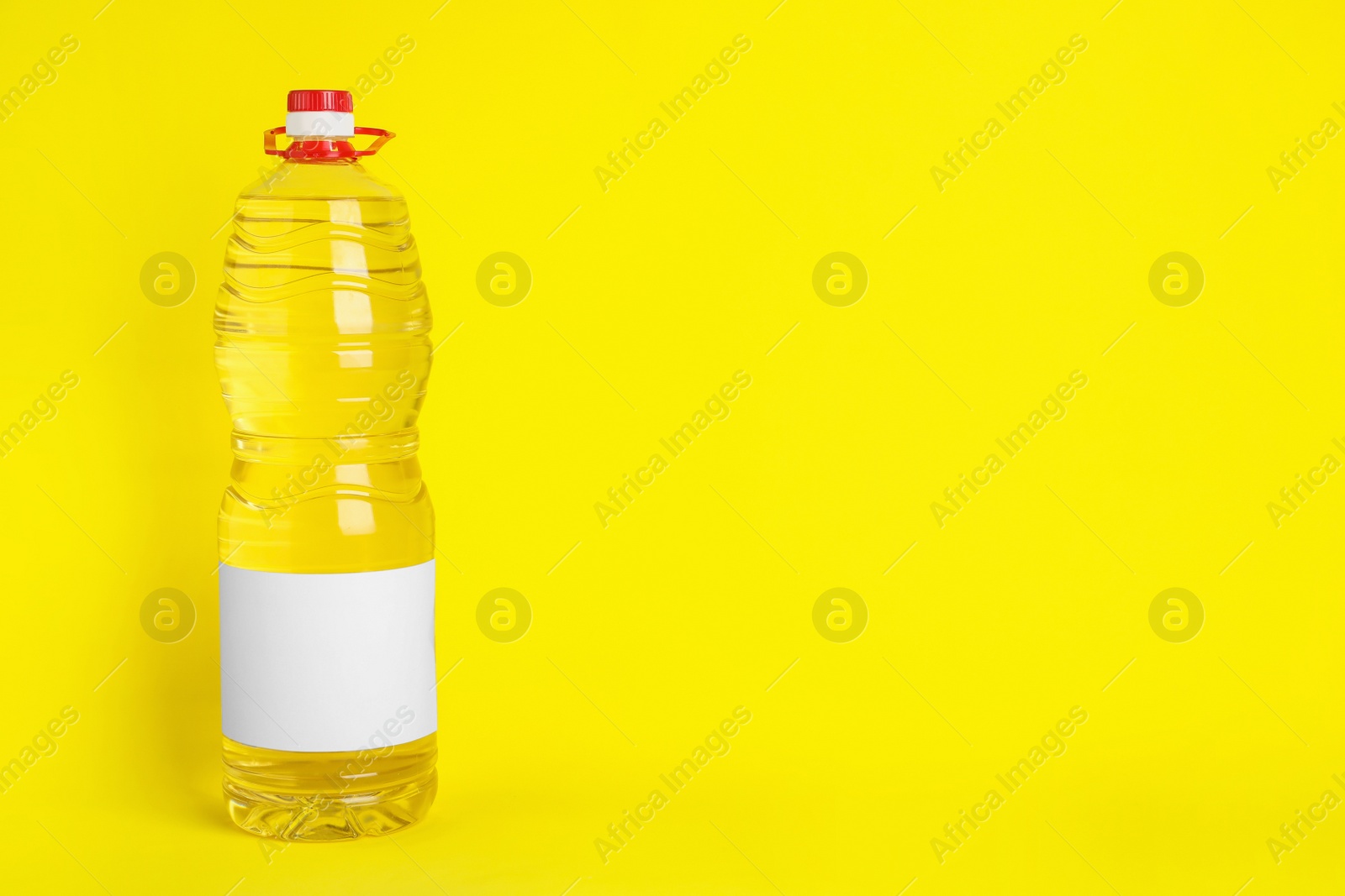 Photo of Bottle of cooking oil on yellow background. Space for text