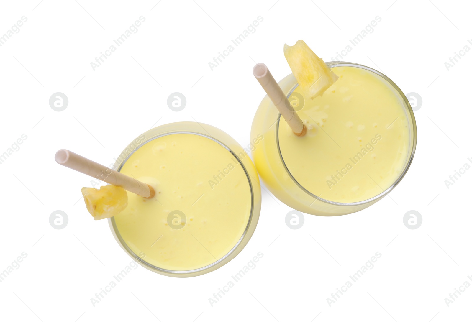 Photo of Tasty pineapple smoothie in glasses with slices of fruit isolated on white, top view