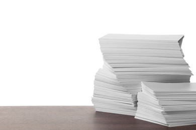 Stacks of paper sheets on wooden table against white background. Space for text