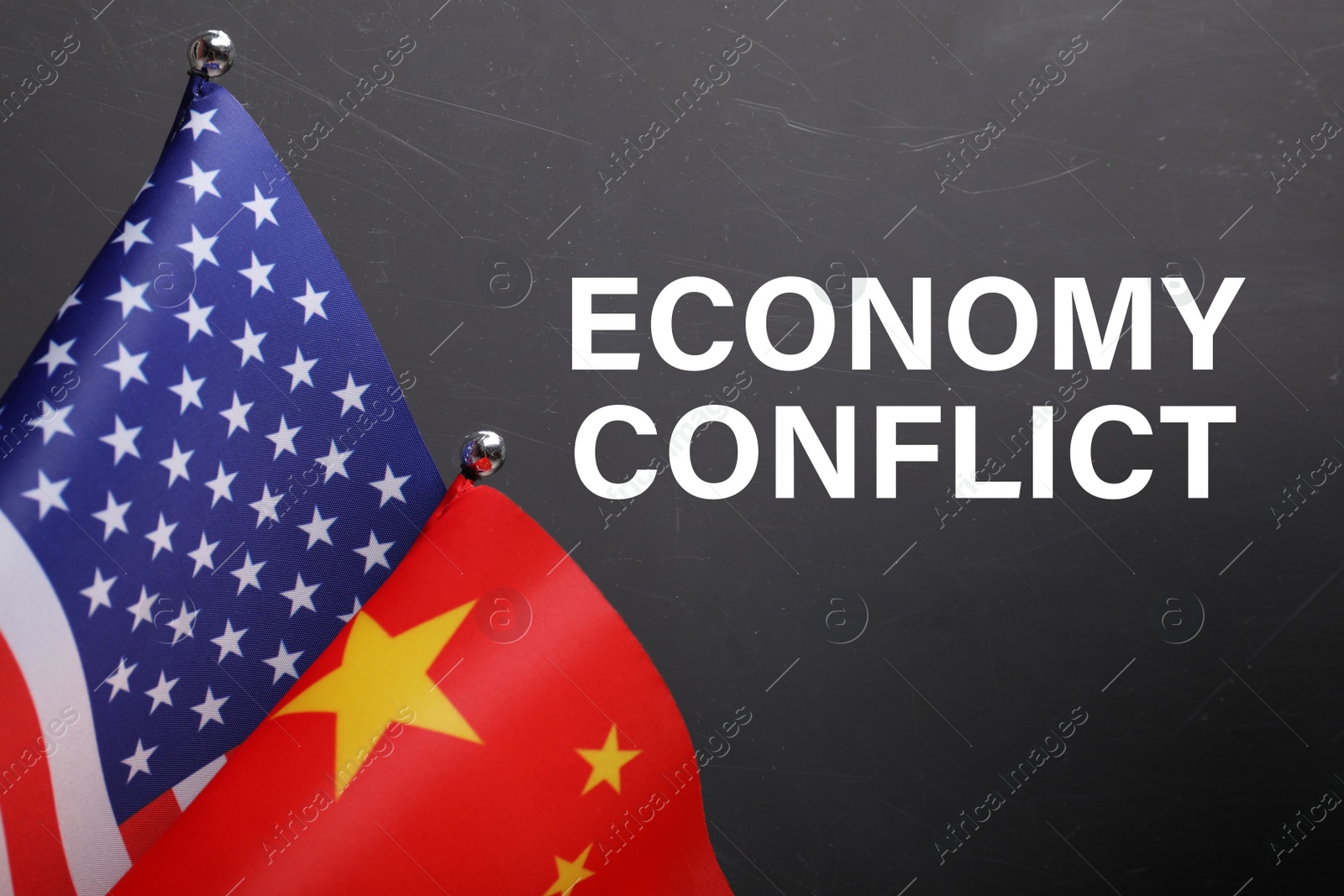 Photo of Phrase ECONOMY CONFLICT, USA and China flags on black background, closeup