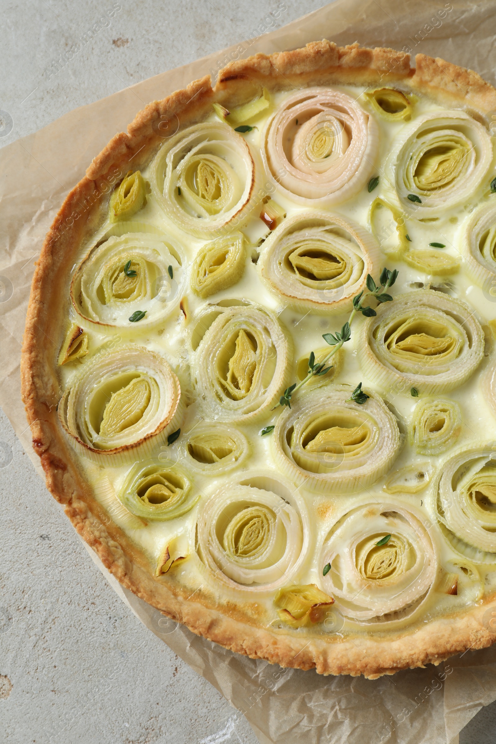 Photo of Tasty leek pie on grey textured table, top view