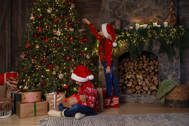 Children near beautiful Christmas tree at home