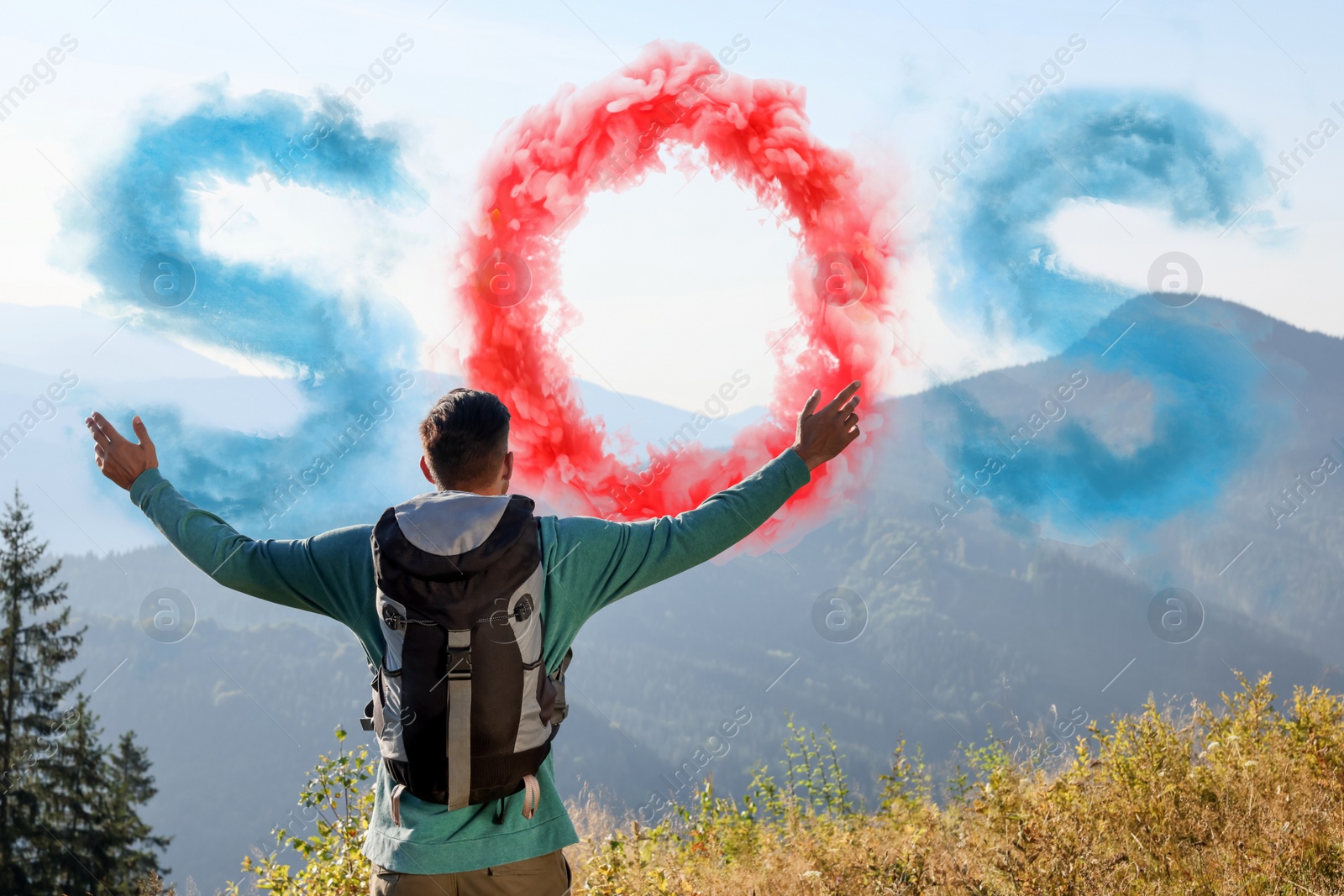 Image of Man with backpack and word SOS made of color smoke bomb in mountains, back view