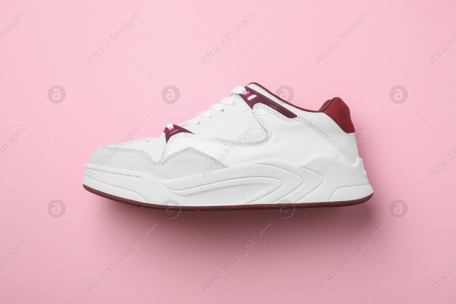 Photo of Stylish sneaker on pink background, top view