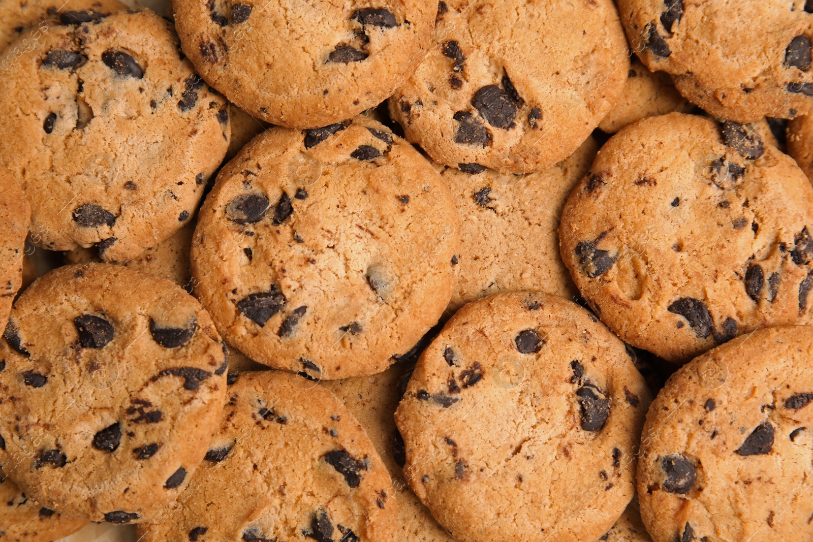 Photo of Tasty chocolate chip cookies as background, top view