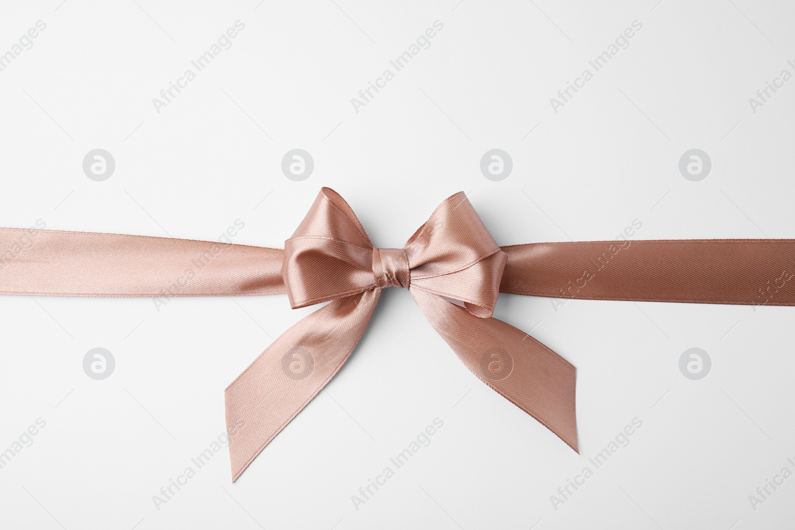 Photo of Beige satin ribbon with bow on white background, top view