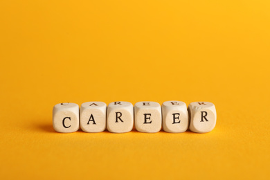 Stone cubes with word CAREER on orange background. Space for text