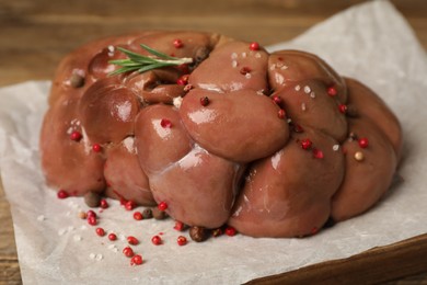 Photo of Fresh raw kidney meat with spices and rosemary on board, closeup