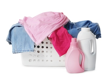 Photo of Laundry basket with dirty clothes and bottles of detergent isolated on white