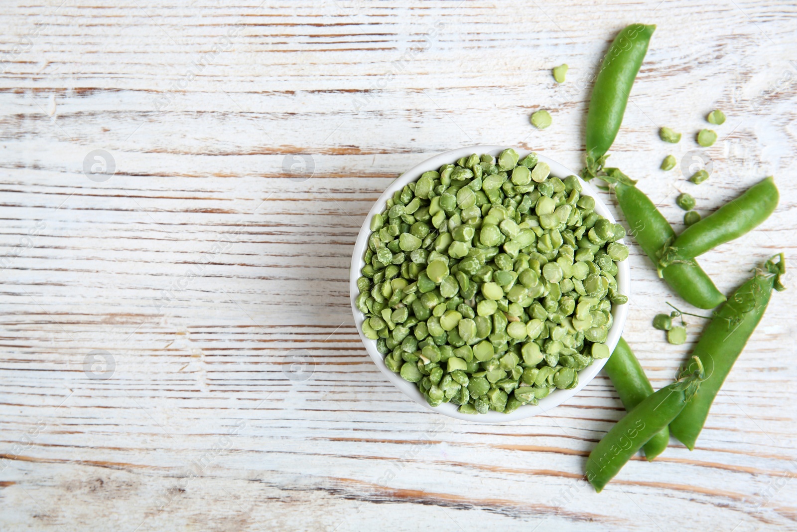 Photo of Bowl with dried peas on wooden background, top view