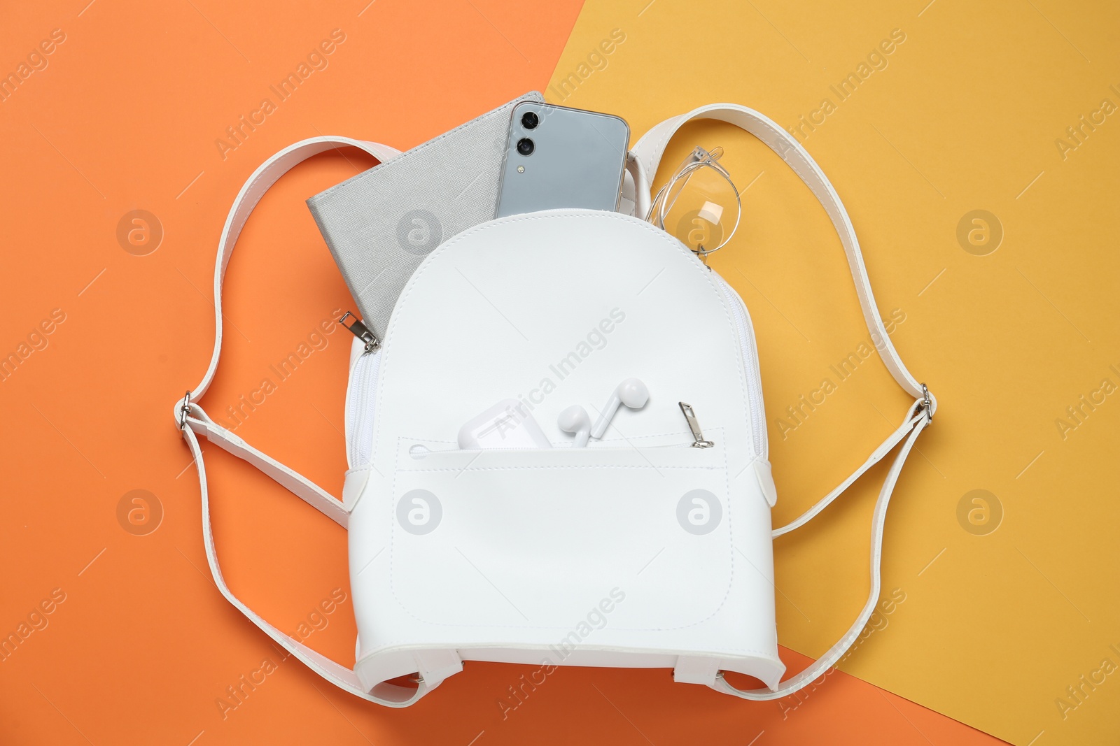 Photo of White backpack with different items on color background, flat lay