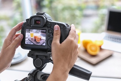 Blogger taking photo of food with professional camera indoors