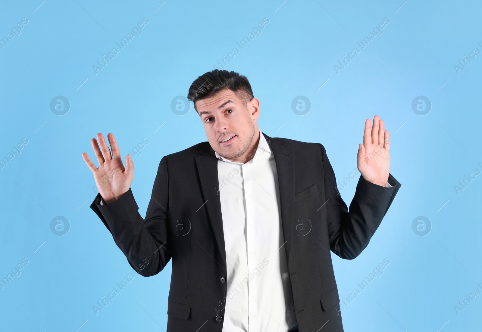 Photo of Man in suit avoiding something on light blue background