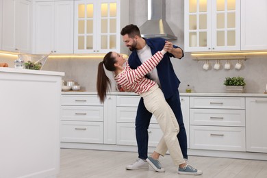 Photo of Happy lovely couple dancing together in kitchen