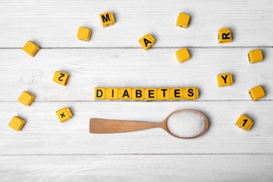 Flat lay composition with word DIABETES and sugar on wooden background