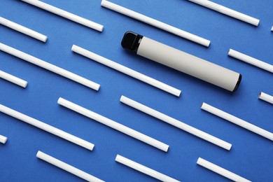 Photo of Disposable electronic smoking device and cigarettes on blue background, flat lay