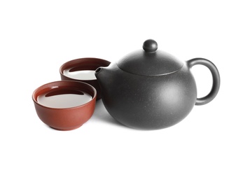 Photo of Cups and teapot of freshly brewed oolong on white background