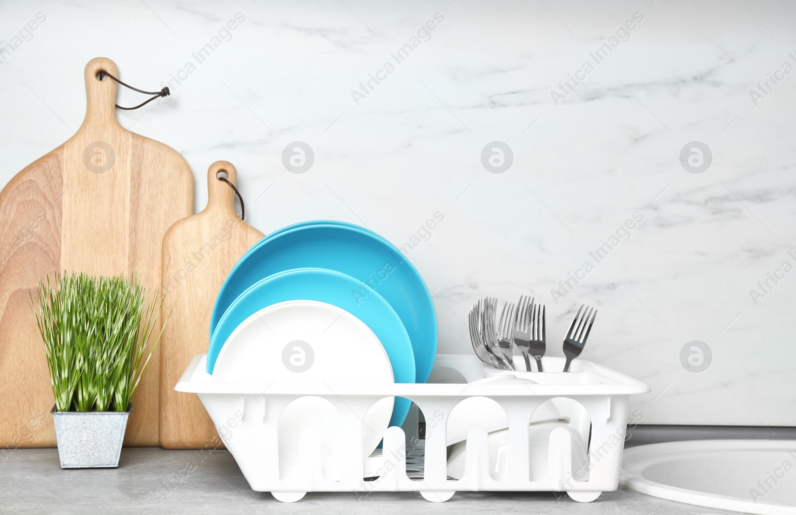 Photo of Different clean tableware near sink in kitchen