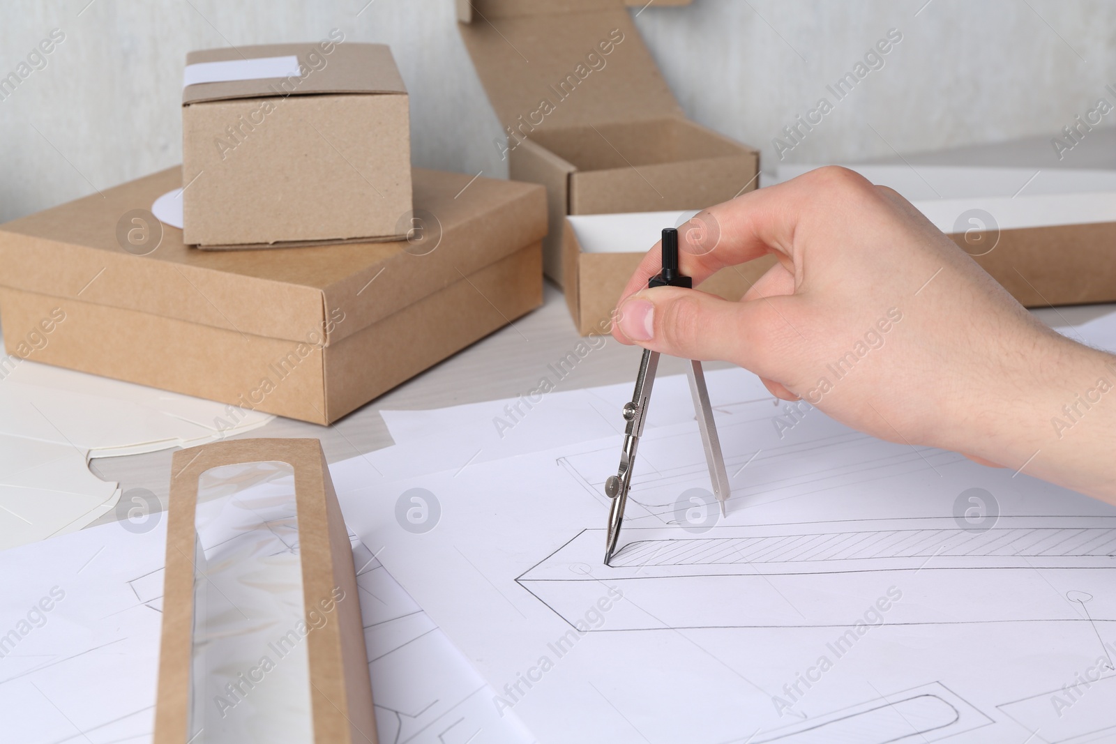 Photo of Man creating packaging design at table, closeup