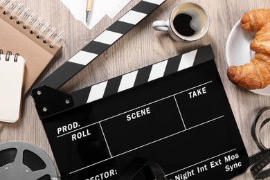 Photo of Flat lay composition with movie clapper on wooden table