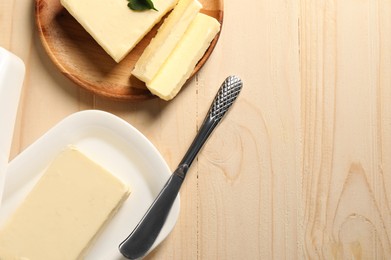 Tasty butter and knife on wooden table, flat lay. Space for text