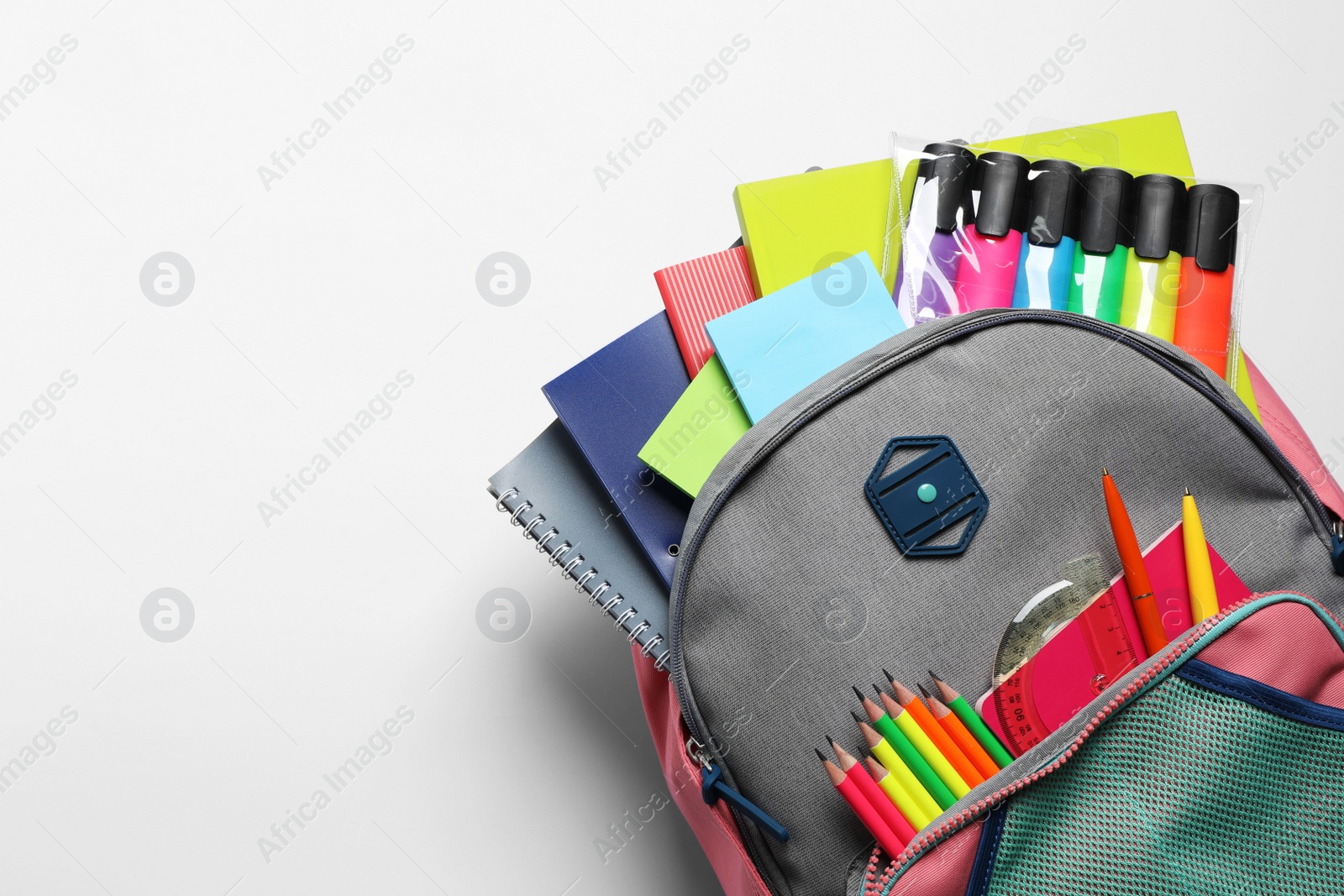 Photo of Backpack with different school stationery on white background, top view. Space for text