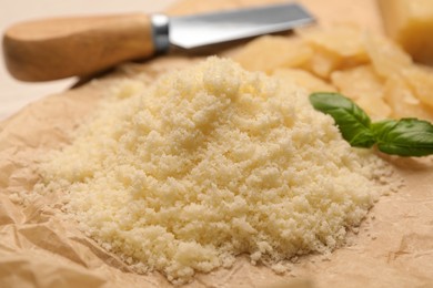 Photo of Delicious grated parmesan cheese on parchment paper, closeup