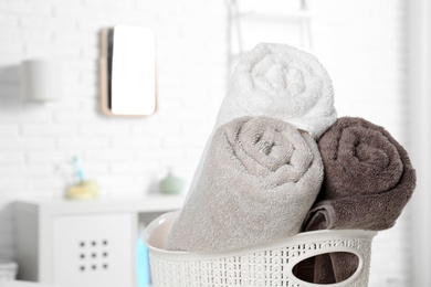 Photo of Basket with fresh rolled towels in bathroom, closeup. Space for text